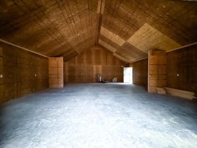 additional living space with concrete flooring and vaulted ceiling