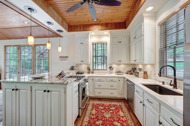 kitchen featuring sink, appliances with stainless steel finishes, hanging light fixtures, white cabinets, and wooden ceiling