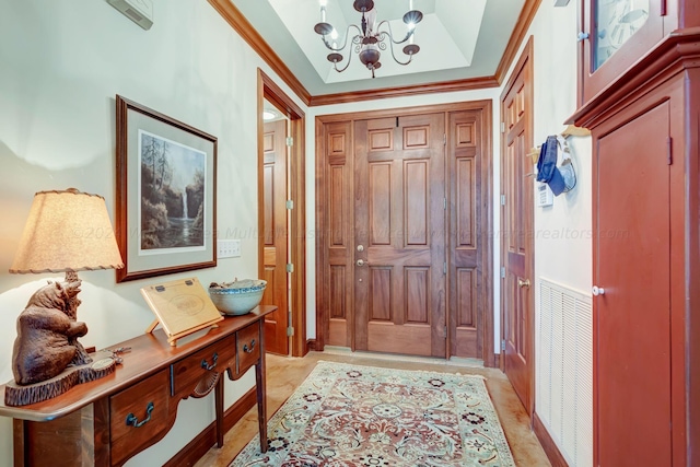 entryway with crown molding and a notable chandelier