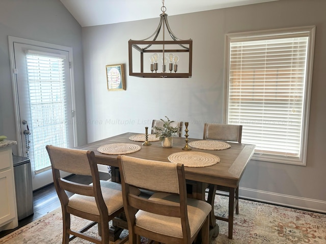 dining space featuring dark hardwood / wood-style flooring and vaulted ceiling