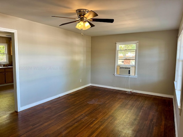 spare room featuring cooling unit, a wealth of natural light, dark hardwood / wood-style flooring, and ceiling fan