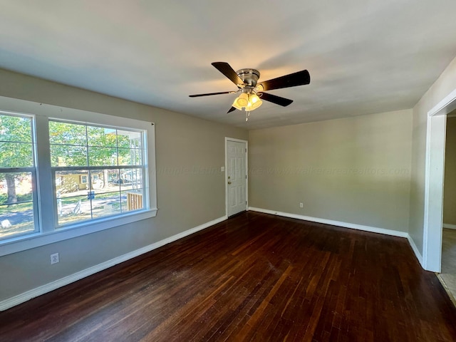 spare room with dark hardwood / wood-style flooring and ceiling fan