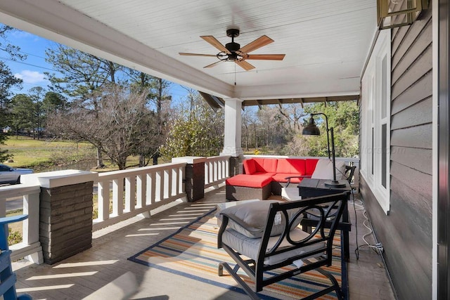 wooden deck with an outdoor hangout area and ceiling fan