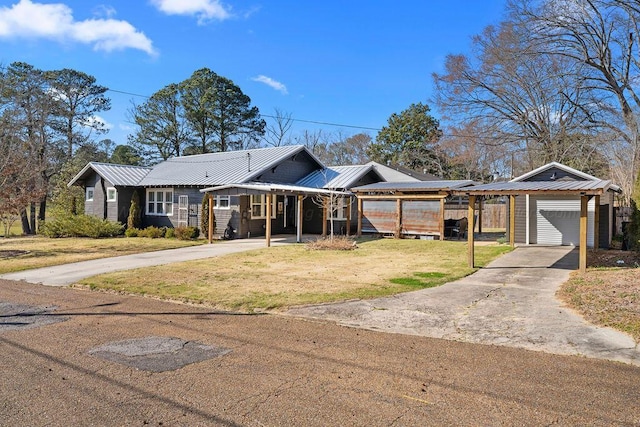 ranch-style house with concrete driveway, a front lawn, an outdoor structure, a detached garage, and metal roof