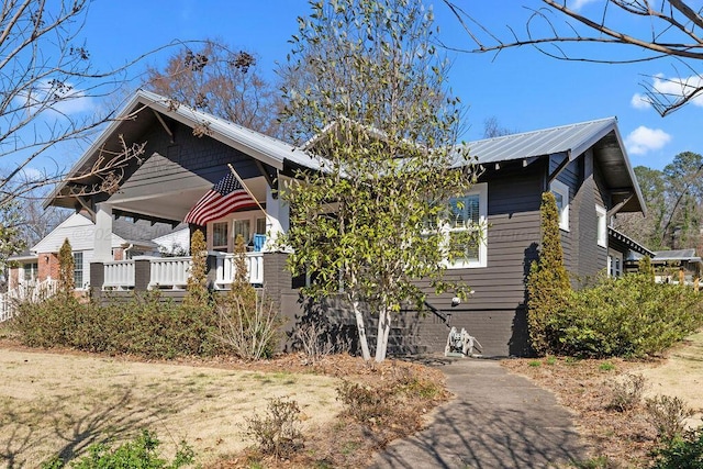 bungalow-style house featuring metal roof and a porch