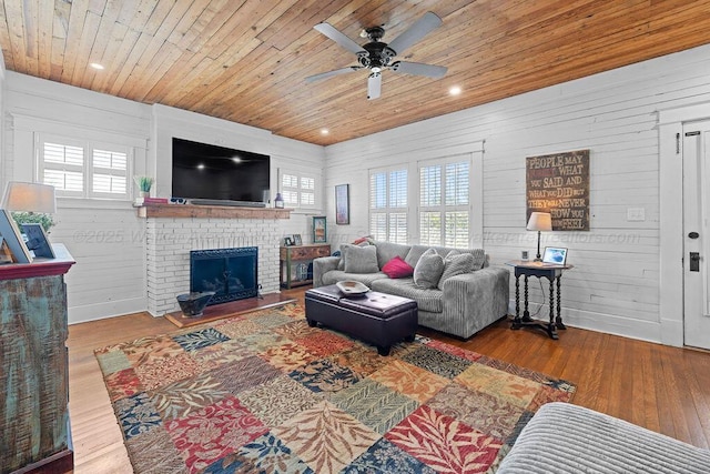 living room with a ceiling fan, wood finished floors, and wood ceiling