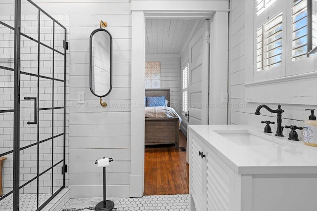 full bathroom with tiled shower, wooden walls, ensuite bath, and vanity