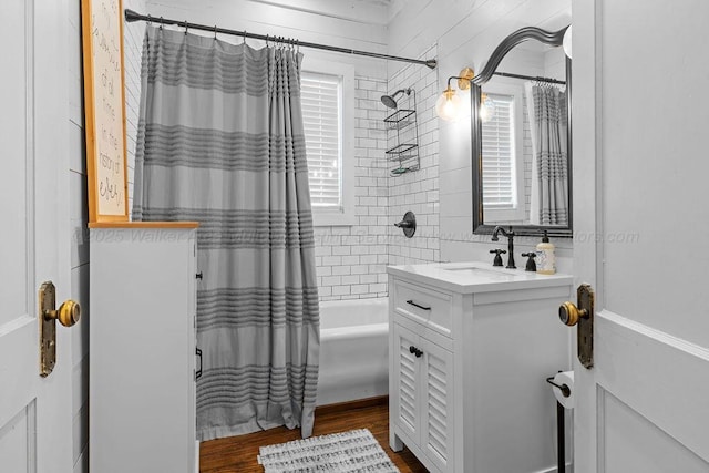 bathroom featuring vanity, shower / bathtub combination with curtain, and wood finished floors