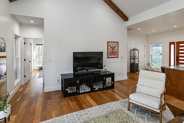 living room featuring high vaulted ceiling, dark hardwood / wood-style floors, beam ceiling, and a wealth of natural light