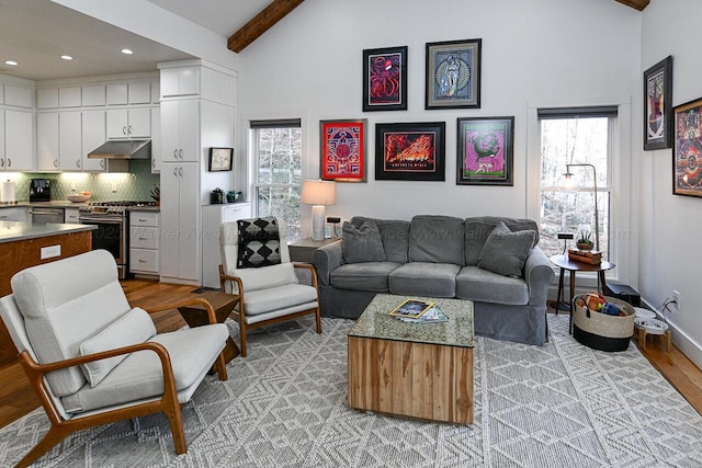 living room featuring lofted ceiling with beams and light hardwood / wood-style flooring