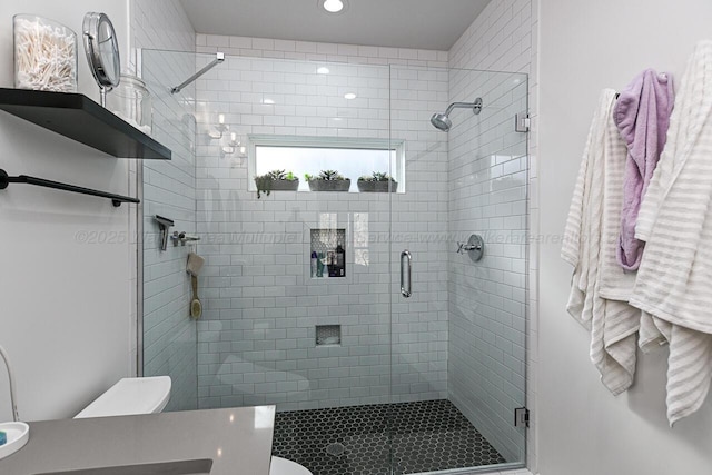 bathroom featuring vanity, an enclosed shower, and toilet