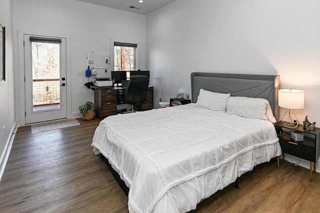 bedroom with access to outside, multiple windows, and dark hardwood / wood-style floors