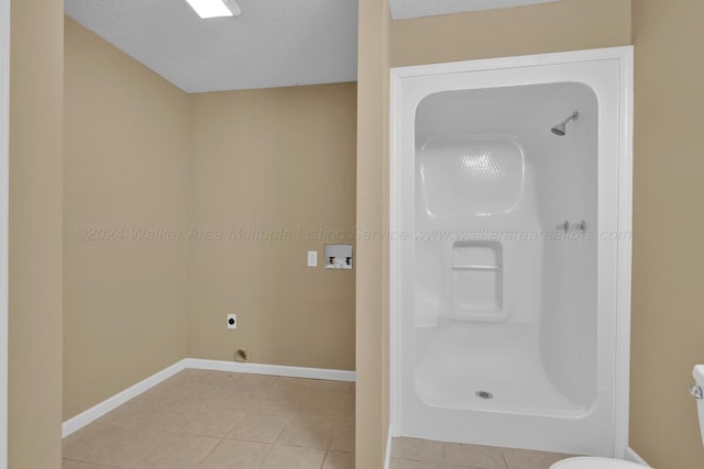 bathroom with tile patterned floors, a textured ceiling, and walk in shower