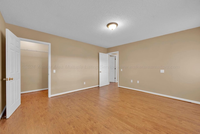 unfurnished bedroom with light hardwood / wood-style floors and a textured ceiling