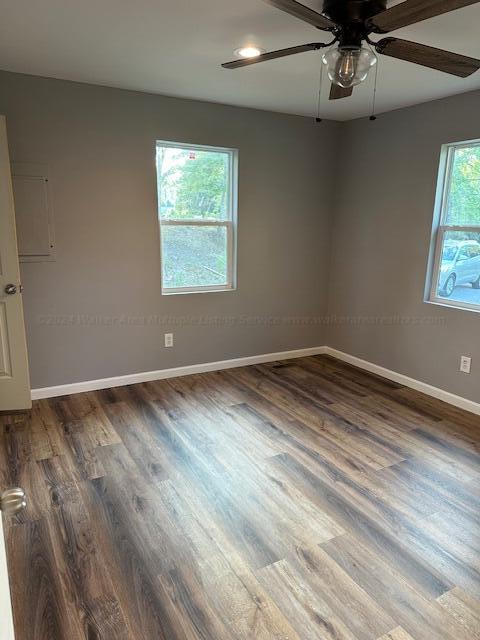 spare room featuring ceiling fan and dark wood-type flooring