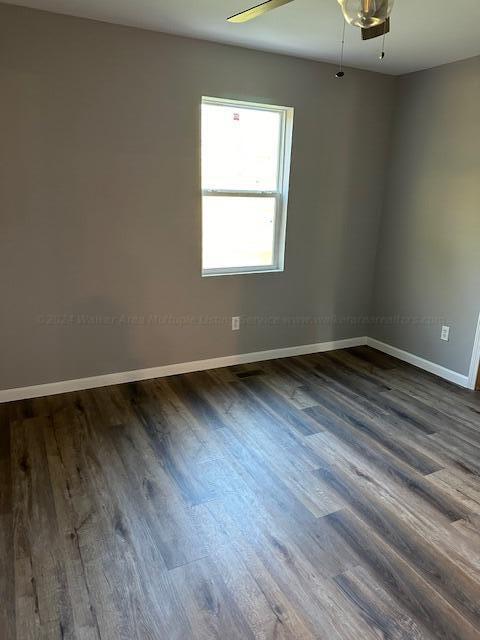 spare room featuring dark hardwood / wood-style floors and ceiling fan