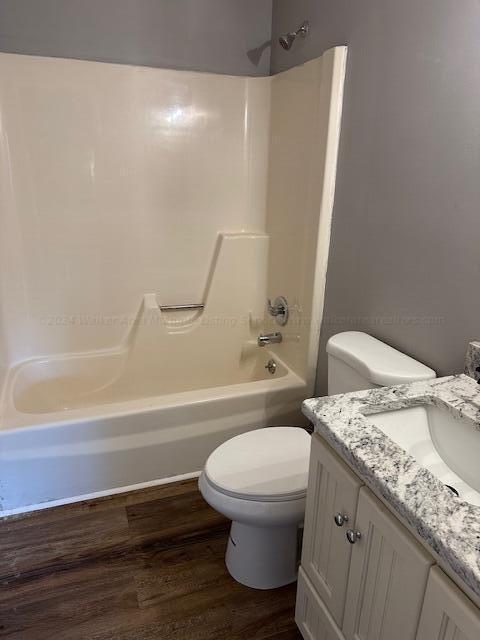 full bathroom with toilet, vanity, tub / shower combination, and hardwood / wood-style flooring