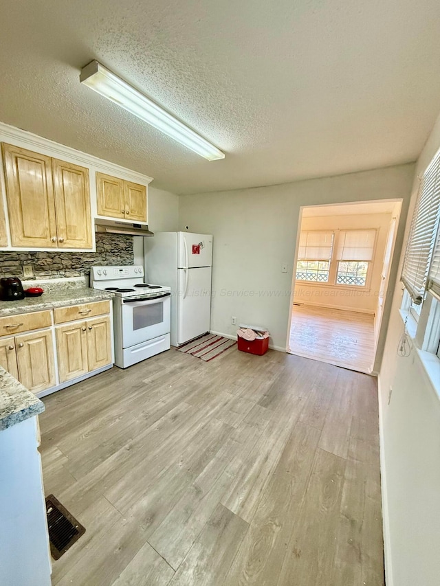 kitchen with white appliances, light brown cabinetry, light wood-style floors, under cabinet range hood, and backsplash