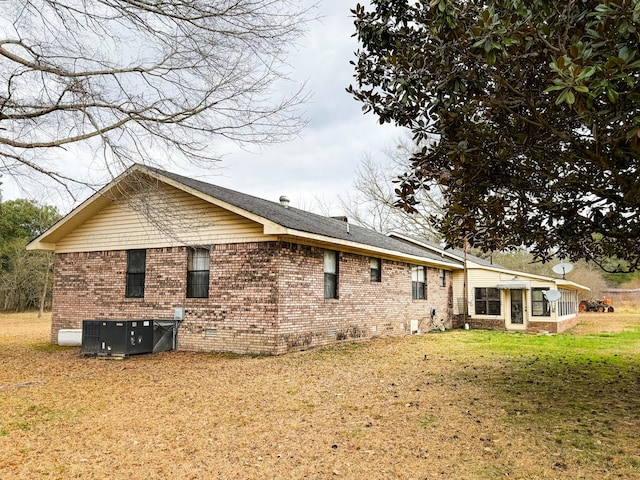 back of property featuring a yard, central AC, and a sunroom