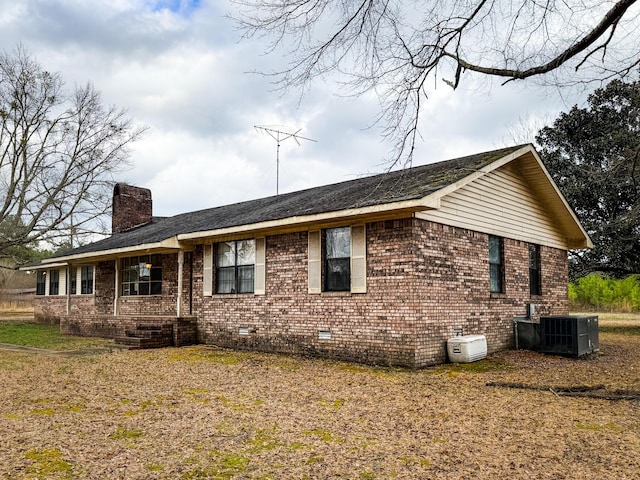 view of side of property featuring central AC and covered porch