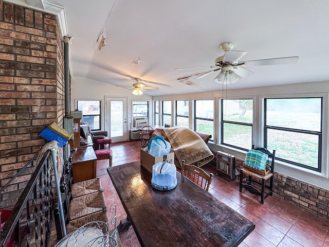 living room with lofted ceiling, ceiling fan, a fireplace, and a healthy amount of sunlight