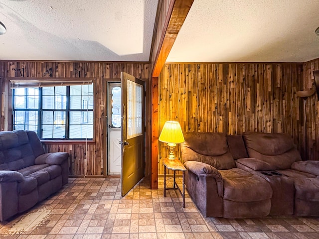 living room featuring wooden walls and a textured ceiling