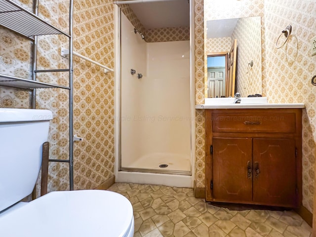 bathroom featuring vanity, a shower with door, and toilet