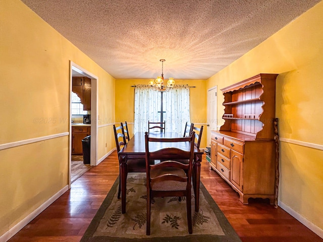 dining space with a notable chandelier, dark hardwood / wood-style floors, and a textured ceiling