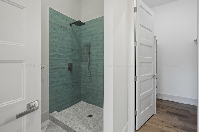 bathroom featuring a tile shower and hardwood / wood-style flooring