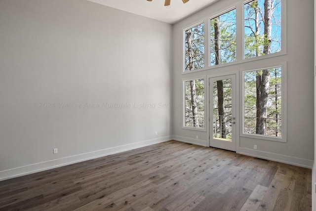 unfurnished room featuring ceiling fan, a healthy amount of sunlight, and light wood-type flooring