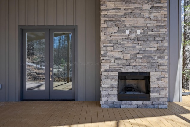 property entrance with a stone fireplace and french doors