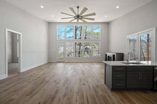 interior space with wood-type flooring, a towering ceiling, ceiling fan, and sink