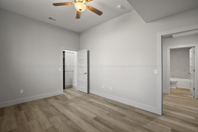 unfurnished bedroom with connected bathroom, ceiling fan, and light hardwood / wood-style flooring