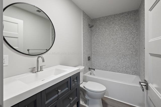 full bathroom with vanity, tiled shower / bath combo, and toilet