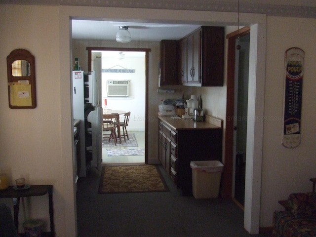 kitchen with light countertops, dark brown cabinets, and a wall unit AC