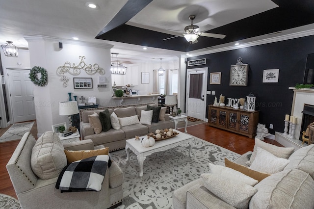 living room with hardwood / wood-style floors, a tray ceiling, ceiling fan, and crown molding