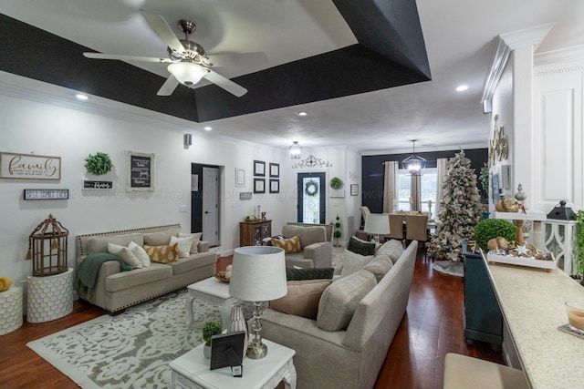 living room with crown molding, dark wood-type flooring, and ceiling fan with notable chandelier