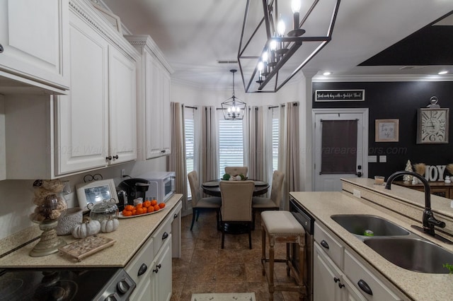 kitchen featuring white cabinets, hanging light fixtures, ornamental molding, and sink