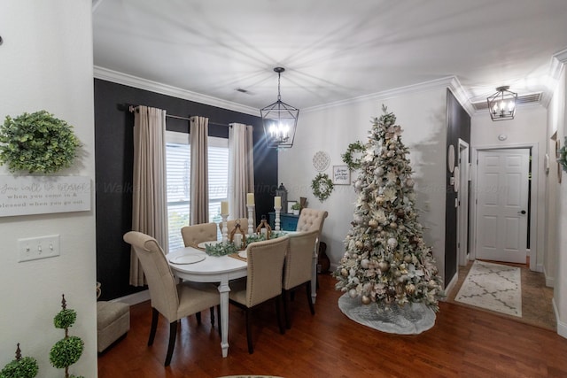 dining space featuring hardwood / wood-style floors, crown molding, and a notable chandelier