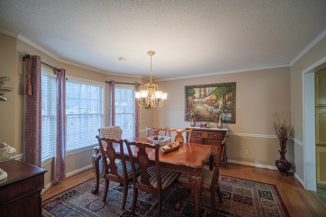 dining space featuring hardwood / wood-style flooring, crown molding, a chandelier, and a textured ceiling