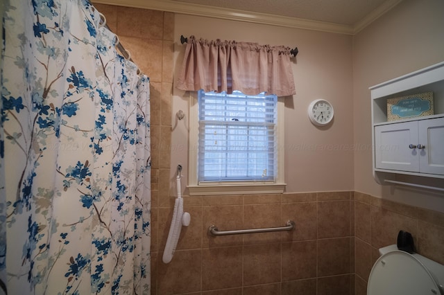 bathroom with crown molding, toilet, a shower with shower curtain, and tile walls