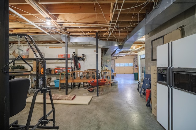 basement featuring white fridge with ice dispenser