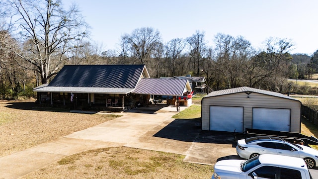 view of front of home with a carport, a garage, covered porch, and an outdoor structure