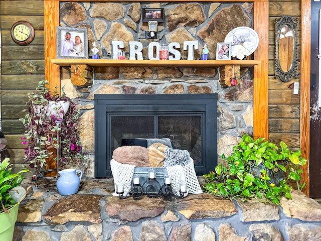 room details with a stone fireplace and wood walls