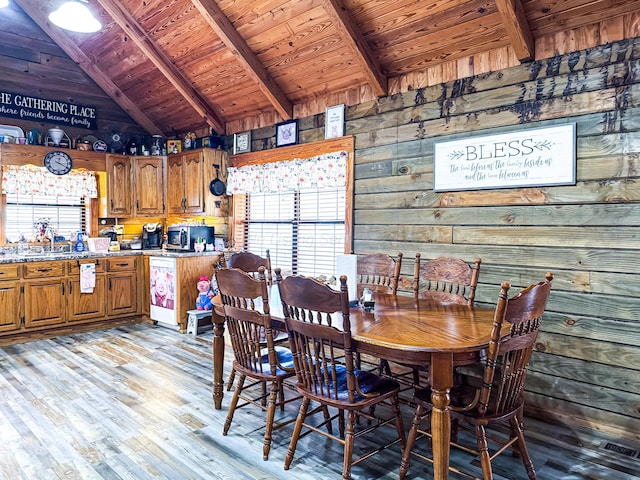 dining space featuring light hardwood / wood-style floors, plenty of natural light, wooden ceiling, and wood walls