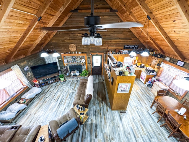 unfurnished living room featuring vaulted ceiling with beams, wooden walls, wooden ceiling, and light hardwood / wood-style floors