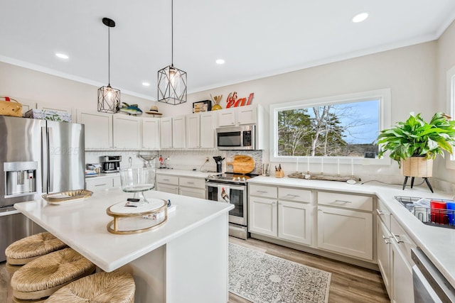 kitchen featuring stainless steel appliances, a kitchen breakfast bar, a kitchen island, and white cabinets