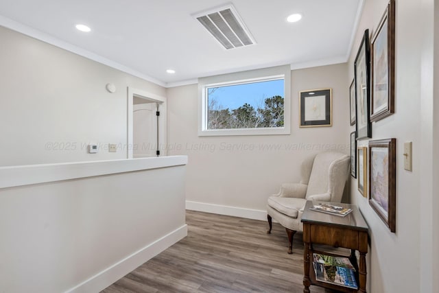 living area featuring wood-type flooring and ornamental molding