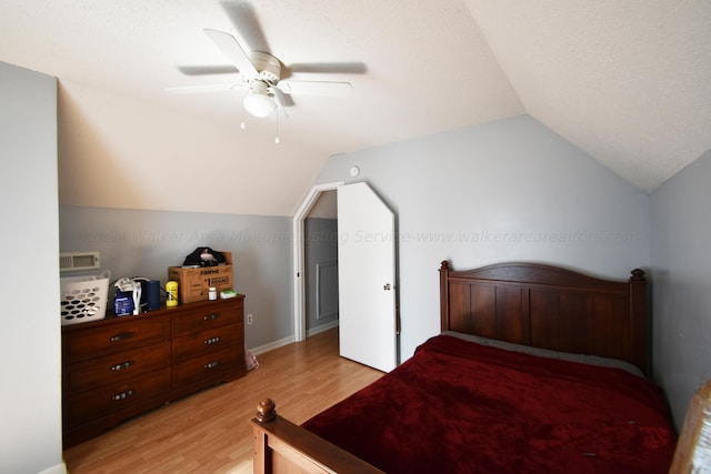 bedroom with a textured ceiling, ceiling fan, lofted ceiling, and light wood-type flooring