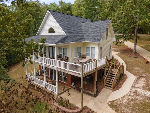 rear view of house with a wooden deck and central AC unit